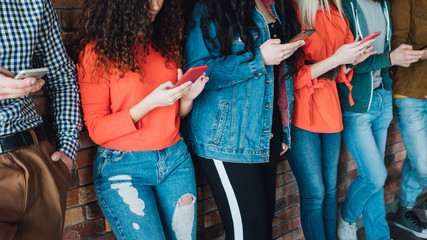 Millennials leisure habit. Young people standing in row, focusing on smartphone screens. Social networks addicted generation.