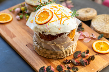 Traditional easter cake with white icing and sugar decor on the wooden board decorated with orange