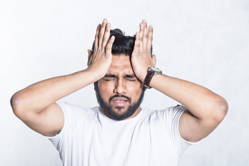 Young man experiencing head hurts, looking miserable and exhausted.