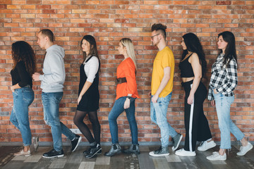 Orderly queue. Millennials moving toward future. Young men women standing in line full length....