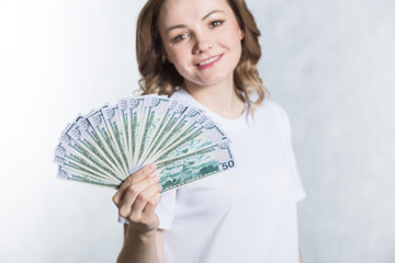 Happy young smiling woman hold us dollar money in hand over white background.