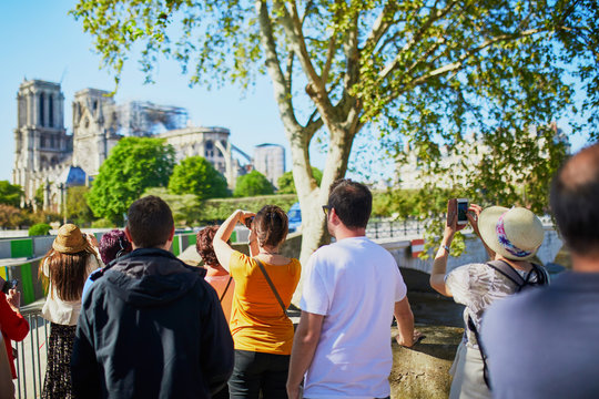 People taking photos of Notre Dame cathedral without roof and spire