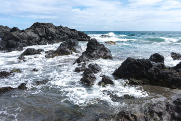 Fototapeta na wymiar Coast rocks in azores. Waves splashing on basalt rocks