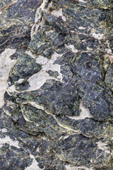 The structure of a stone of green color damaged by bad weather with moss-grown. Ready photo background. Soft focus. Macro.