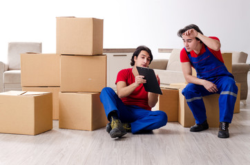 Two young contractor employees moving personal belongings