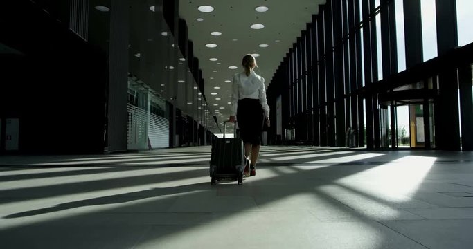 Business woman walking with wheeled bag