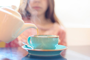 girl pours hot tea. selective focus