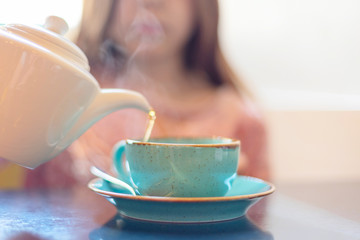 girl pours hot tea. selective focus