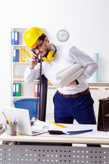 Young male architect working in the office 