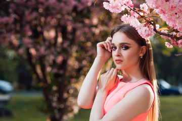 Spring, girl near a flowering tree.  Girl in spring garden. Spring concept. 