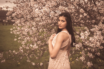 Attractive young beautiful lady, enjoying spring plum blossom flowers