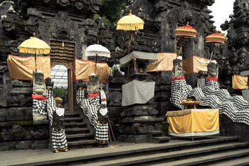 Balinese Hindu temple decorated for traditional festival. Stone dragons dressed for Balinese Hindu festival