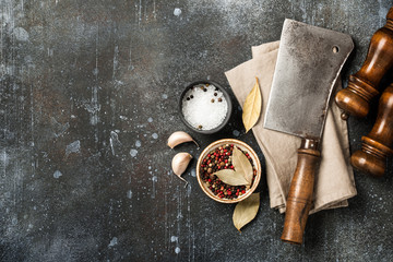 Cooking background with vintage butcher cleaver, spice shakers and spices