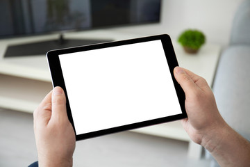 man hands holding computer tablet with isolated screen in room