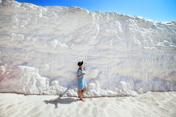 Young girl in hat looking on travertine pools and terraces in Pamukkale. Cotton castle in southwestern Turkey