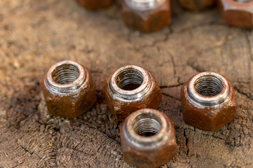 large rusty nuts on wooden background