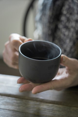 middle aged woman holds a tea cup