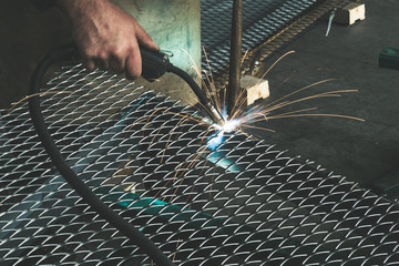 Worker welding steel mesh to the frame with MIG technology