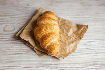 Freshly baked croissants on wooden rustic background. Tasty croissants with copy space