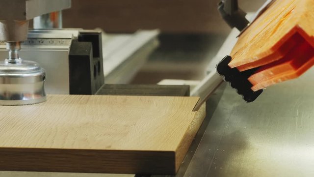 Cutting chipboard at 45 degrees on professional equipment. Close-up