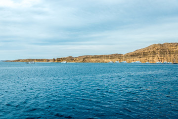 Naklejka premium Seascape, view of the blue sea with high bald mountains in the background
