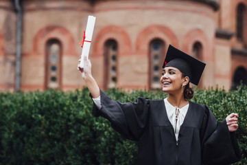 Happy graduated student girl, congratulations of education success.With diploma! Wearing at black...
