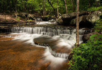 Collins creek cascade in Arkansas.  A slow shutter speed captures the water flowing over the rocky steps of the Arkansas forest just outside of Springs a hot spot for hikers and picnic goers. 