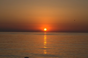 Sunset with large yellow sun under the sea surface