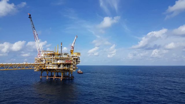 Songkhla, Thailand-February 08, 2019 : Red Supply boat transfer cargo to oil and gas industry and moving cargo from the boat to the platform. Boat is waiting transfer cargo and crews to platform.