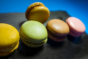 MACARONS ON BLACK SLATE AND BLUE BACKGROUND