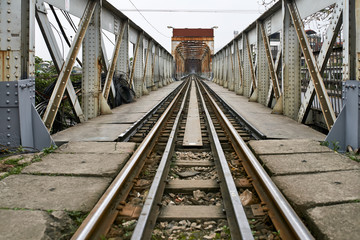 Fototapeta na wymiar Old railroad bridge with rusty metal constructions