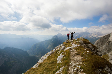 Hikers on hill under Prisojnik peak, Julian Alps, Slovenia. 