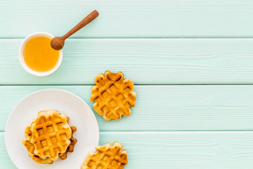 Traditional belgian waffles with honey on served mint green wooden table background top view mockup