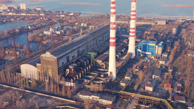 Aerial view of CHP plant (factory) - coal-fired power station with fuming chimney at sunset
