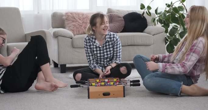 Teenage girls having fun while playing foosball
