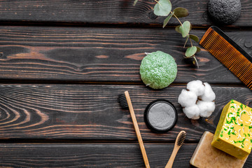 soap, comb, bamboo dental cleaning brush and toothpaste for zero waste lifestyle on wooden background top view mock up