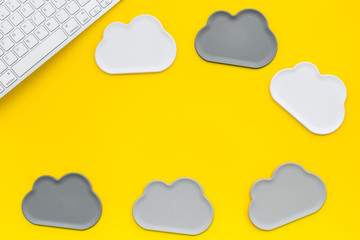 cloud service concept with clouds and keyboard on yellow background top view mockup