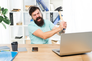 Outdated software. Computer lag. Reasons for computer lagging. How fix slow lagging system. Hate office routine. Man bearded guy headphones office swing hammer on computer. Slow internet connection - obrazy, fototapety, plakaty