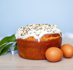 Easter cake and colored eggs on blue background. Holiday food and easter concept. Selective focus. Copyspase