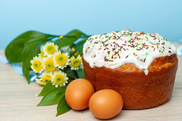 Easter cake and colored eggs yellow flower blossoms on background. Holiday food and easter concept. Selective focus. Copyspase