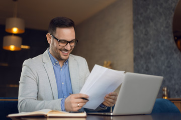 Happy businessman working on reports in the office