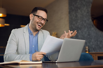 Happy businessman working on reports in the office