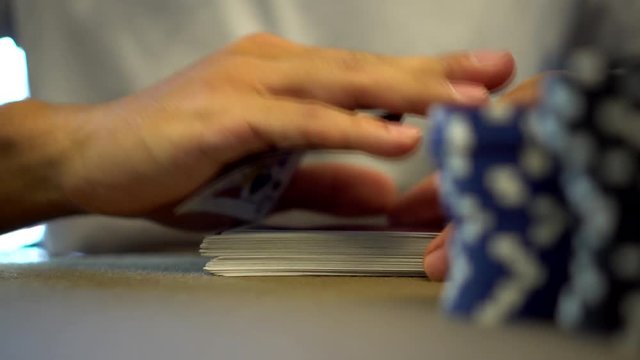 secretly hiding a playing card at gambling table with poker chips