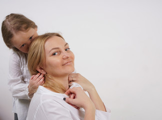 real family of caucasian mother and daughter in white shirts in the studio background