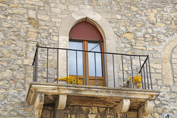 Balcony with flowers on a stone house, San Marino. UNESCO