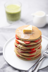 Sweet Homemade Pancakes with strawberries and matcha latte. Ready for breakfast.