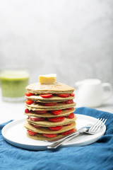 Sweet Homemade Pancakes with strawberries and matcha latte. Ready for breakfast.