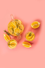 Citrus lemonade water with lemon sliced , healthy and detox water drink in summer on living coral background. space for text