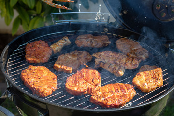 steaks cooking over flaming grill