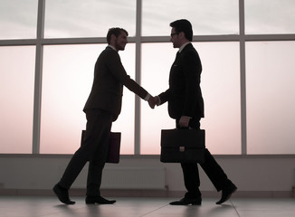 Fototapeta premium two business people holding out their hands for a handshake